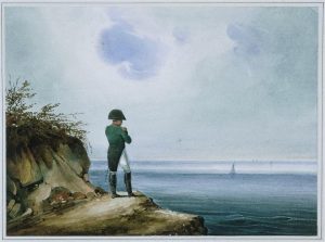 Napoleon in white pants, long green jacket, black hat, and black boots standing on the rocky edge of Saint Helena looking out towards the ocean