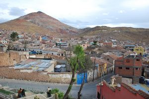 City of Potosí today with homes, a curved wall and street, and mountain in the background