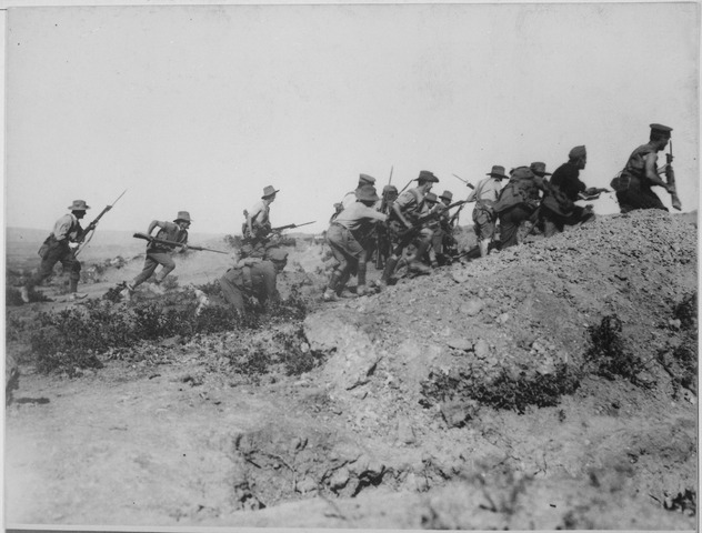 Group of Australian soldiers charging up hill towards Ottoman trench with bayonet guns drawn