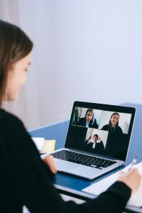 person in an online meeting on a laptop with three people