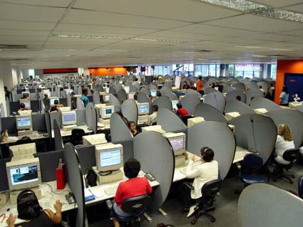 Many people at workstations in a call center.