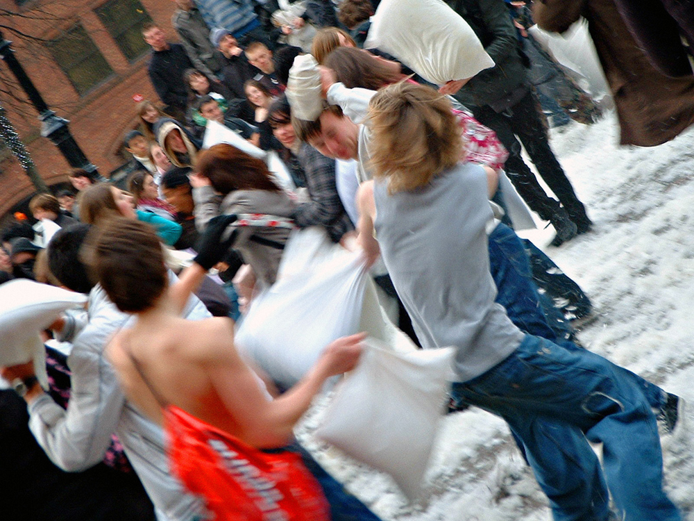 People having a pillow fight outdoors.