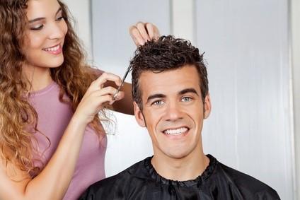 Portrait of happy client getting haircut from female hairdresser at salon