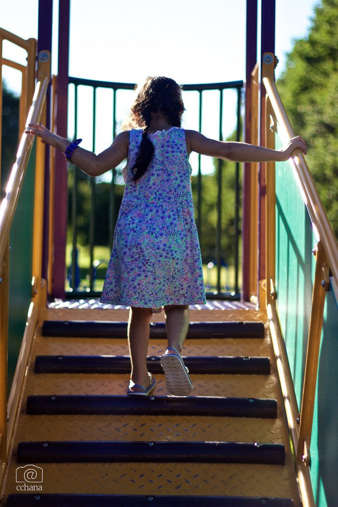 A child walking up the stairs at a playground