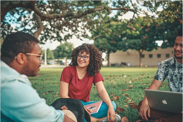 3 people sitting outside in the grass