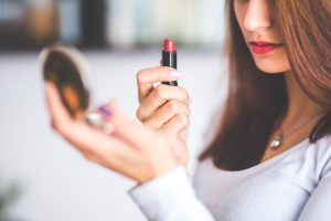A lady applying lipstick
