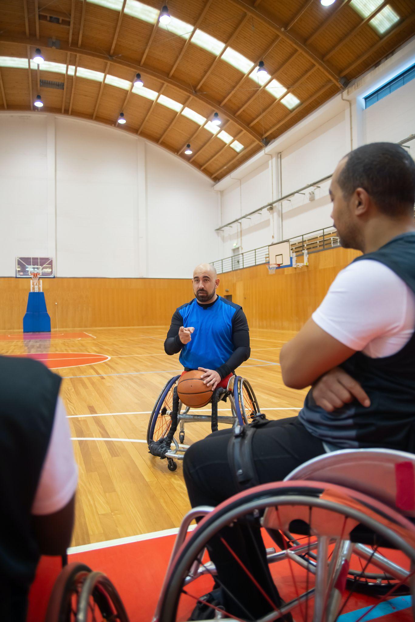 Men in wheelchair on a basketball court getting ready to play basketball