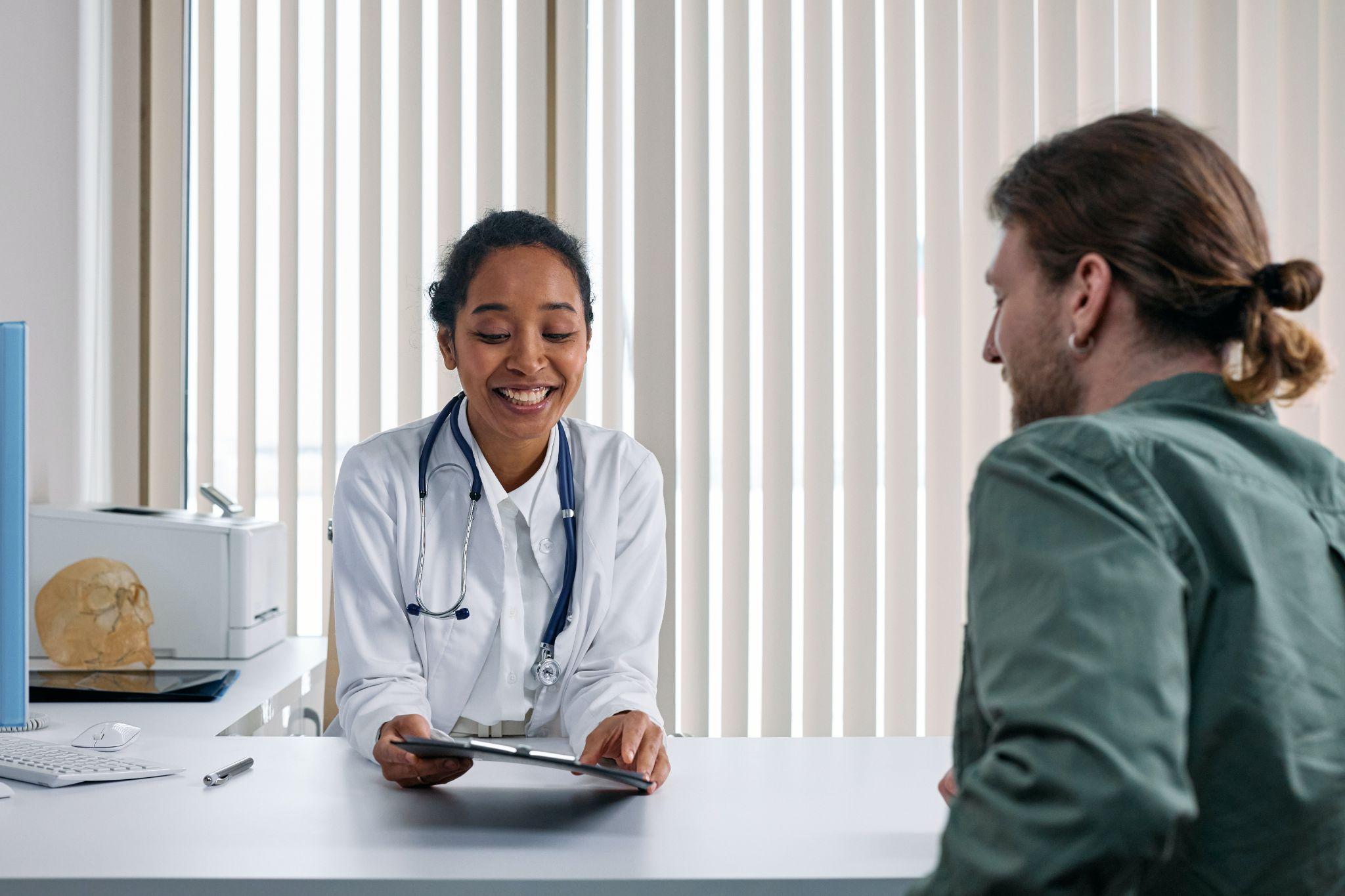 female doctor sitting across from male patient discussing his health