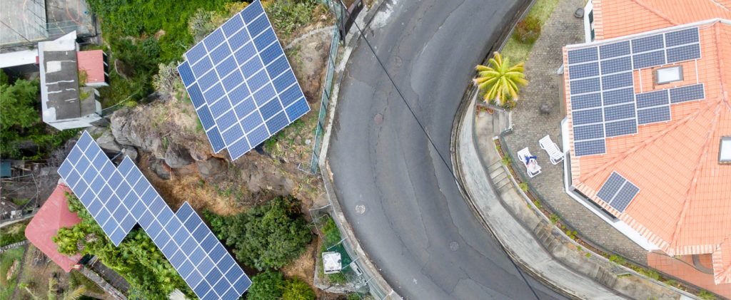 Aerial view of buildings and roadway with solar panels.