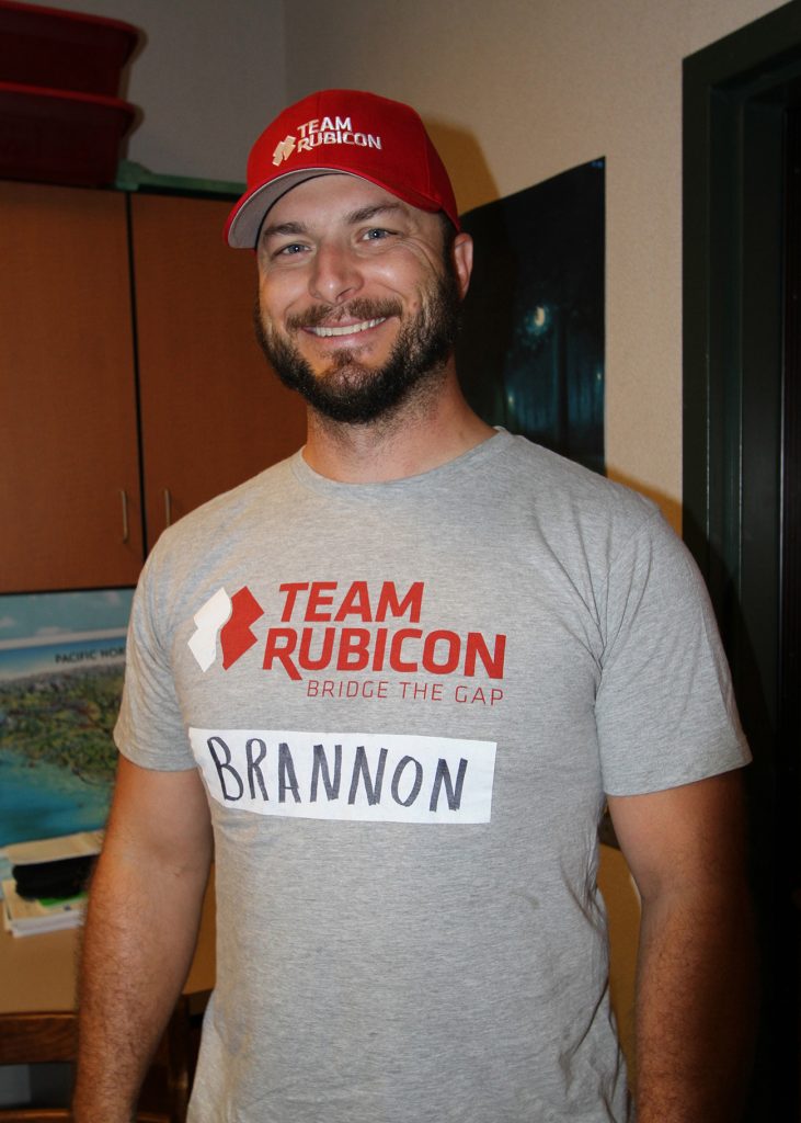 Smiling man wearing Team Rubicon shirt and hat.