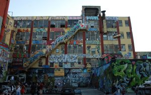 The rear of a building covered in graffitti.