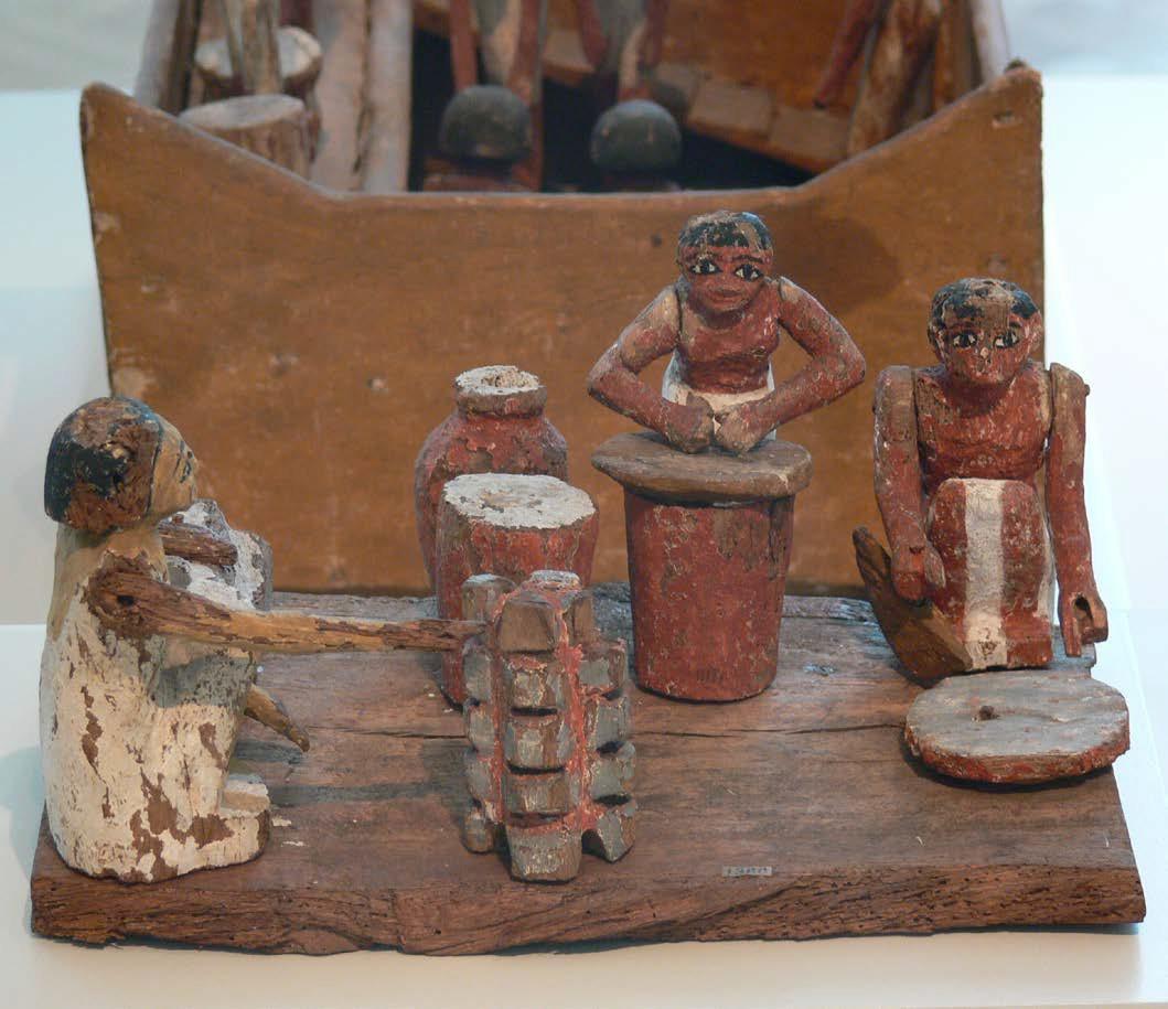 Female figurines from ancient Egypt made of clay or wood. The figurines are performing everyday tasks such as making bread and beer
