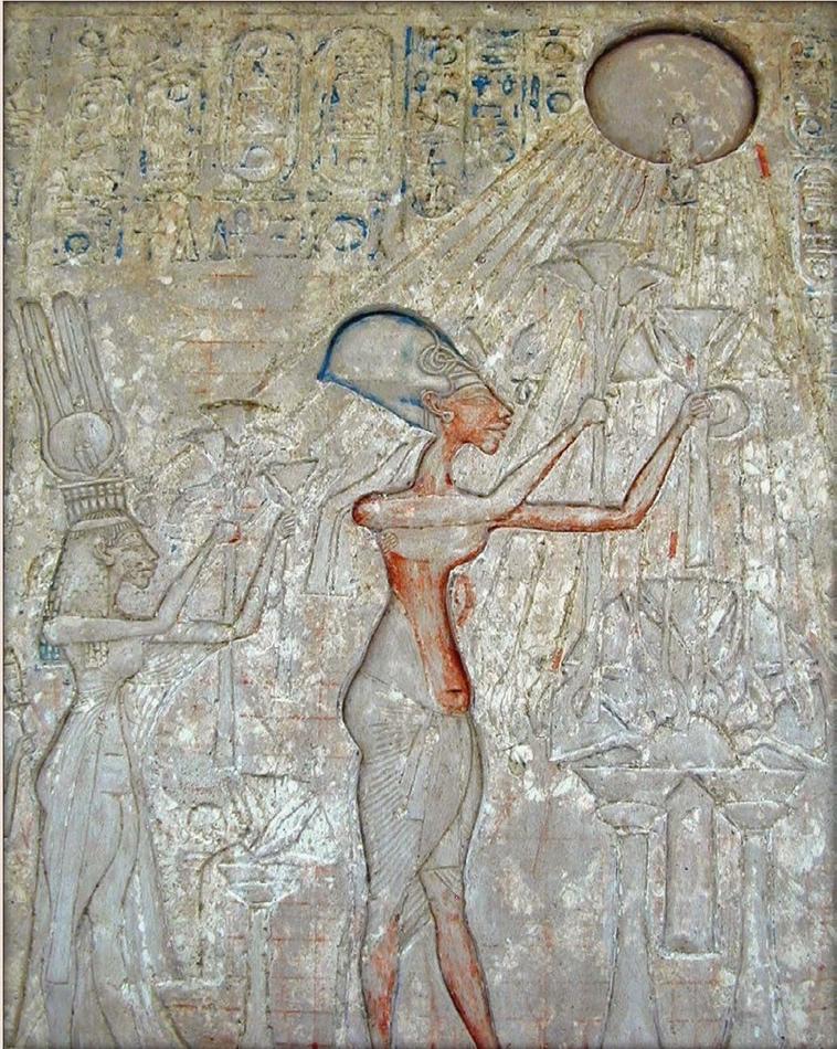 Image carved into stone showing the adoration scene of Aten with a man and a woman holding flowers up towards the sun