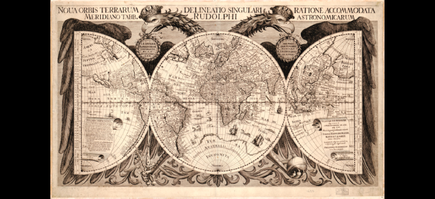 alt="This image shows a map of the world. The margins around the map are decorated with the Germanic, double-headed imperial eagle. The Latin words “Noua orbis terrarum delineatio singulari ratione accommodata meridiano tabb. Rudolphi astronomicarum” appear above the image."