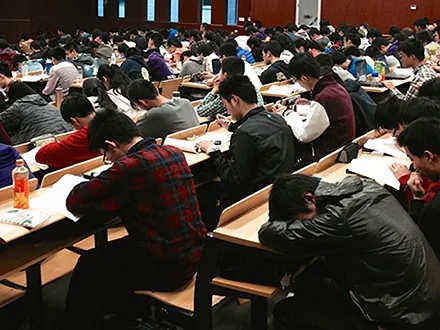 Many students studying in a large lecture hall