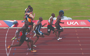 A photograph of 8 male runners in a track race.