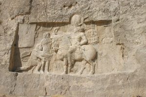 A Stone depicting the defeat of the emperor Valerian, kneeling on the left, before the Persian king Shapur I, on horseback on a wall
