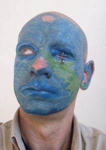 Man with face completed tattooed