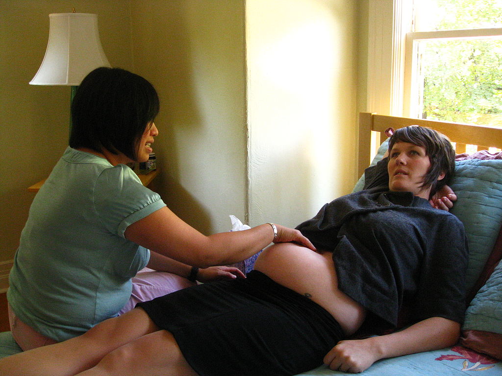 Photo a midwife making a home appointment with an expectant mother.