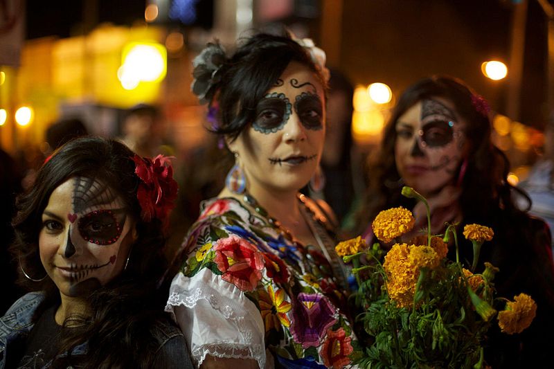 Photo shows three women costumed for Dia de los Muertos Celebration or Day of the Dead.
