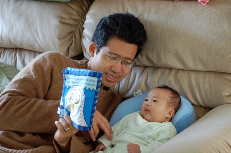 Parent reading a book to a baby