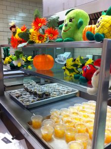 Photo of a school lunch counter with fruit in cups.