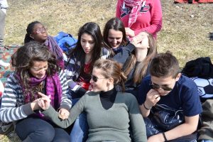 Photo of high school students sitting around outside during a lunch break.