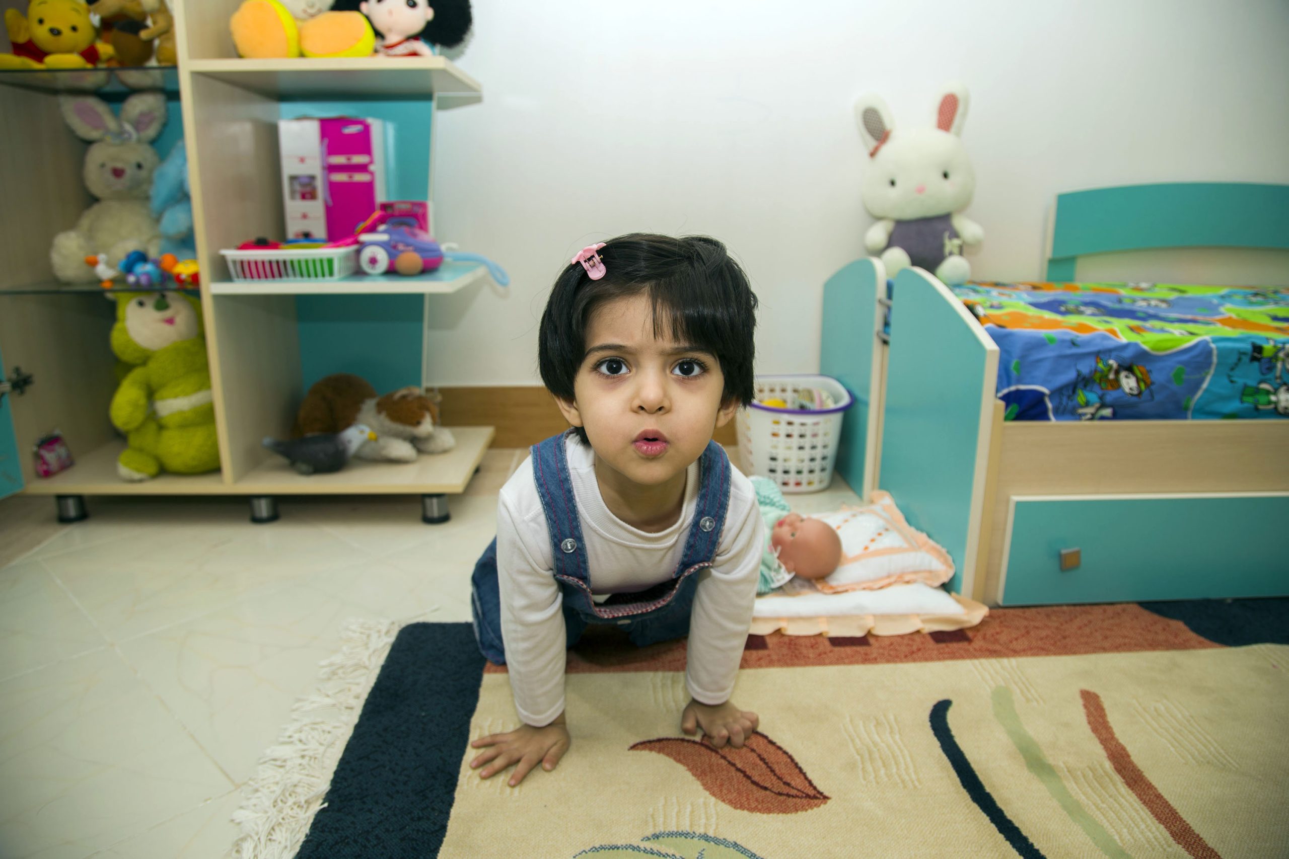 Toddler in a playroom on the floor.
